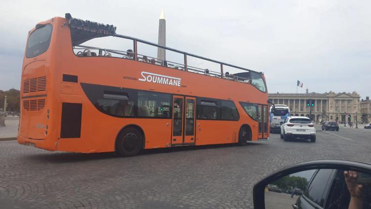 bus orange devant la Concorde à Paris - Autocars-soummane